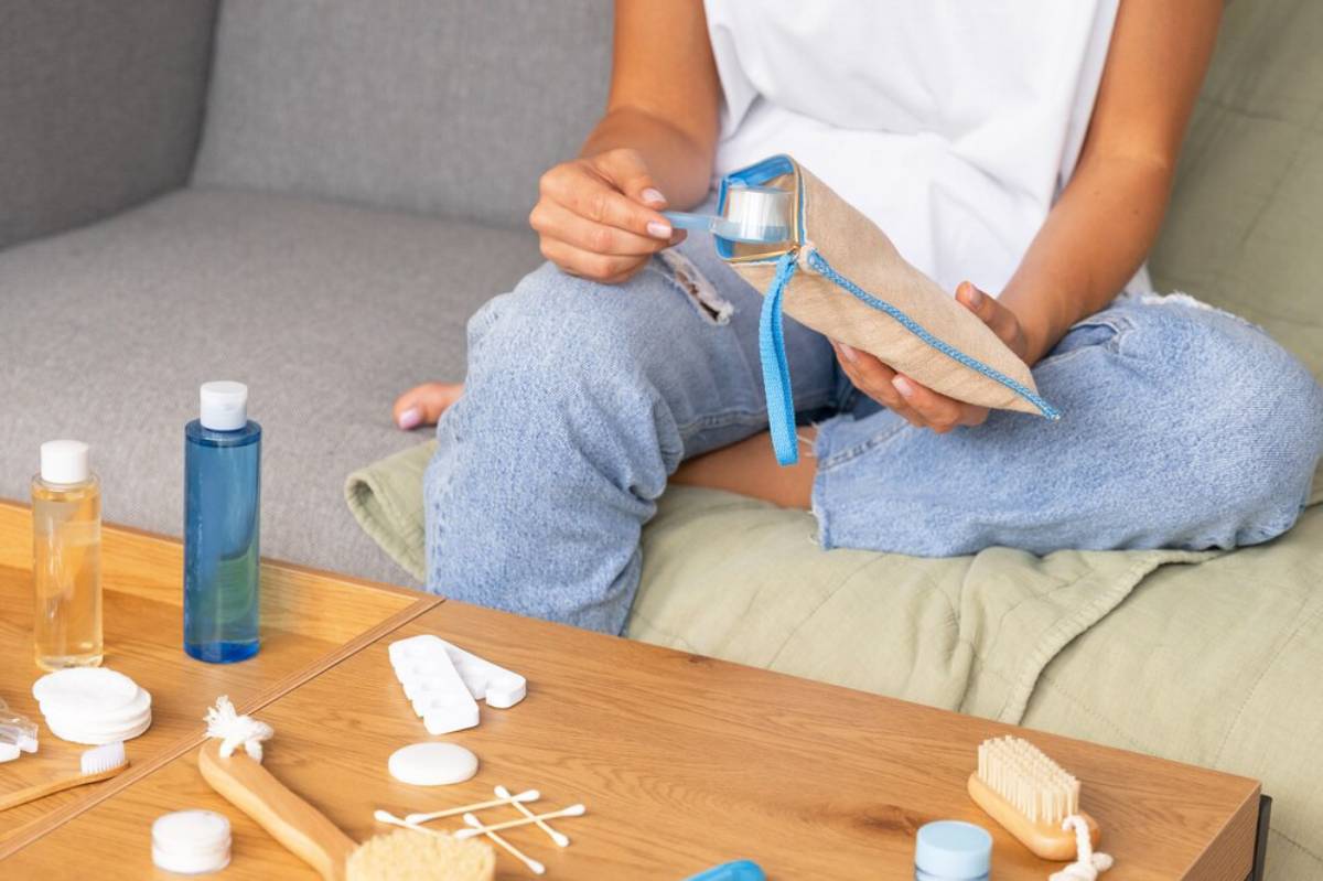 A child in a lab coat holds a stretchy purple slime, surrounded by colorful craft supplies and containers on a table.